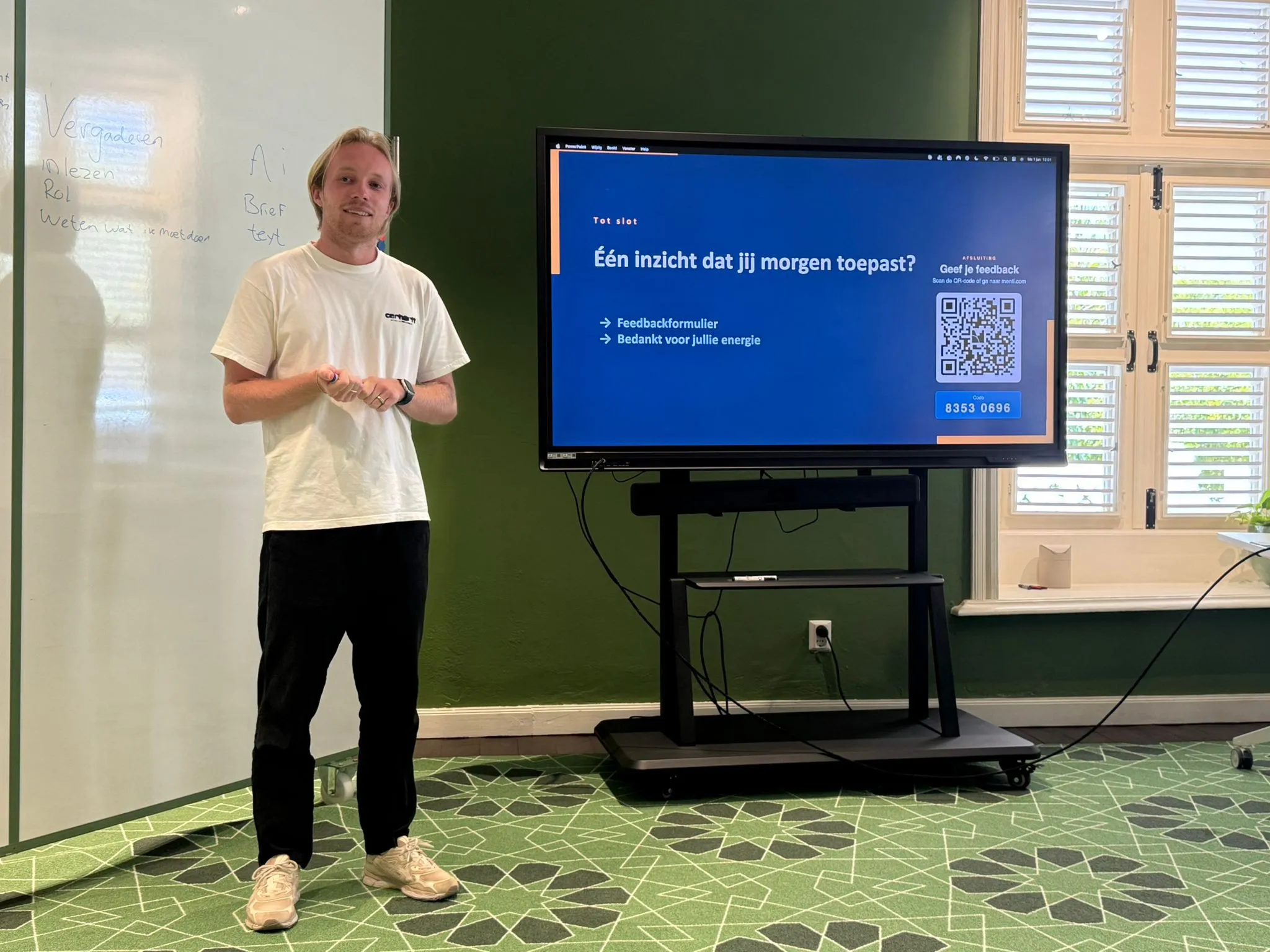 Portret van Jesse Venniker tijdens een training, voor een whiteboard en een scherm